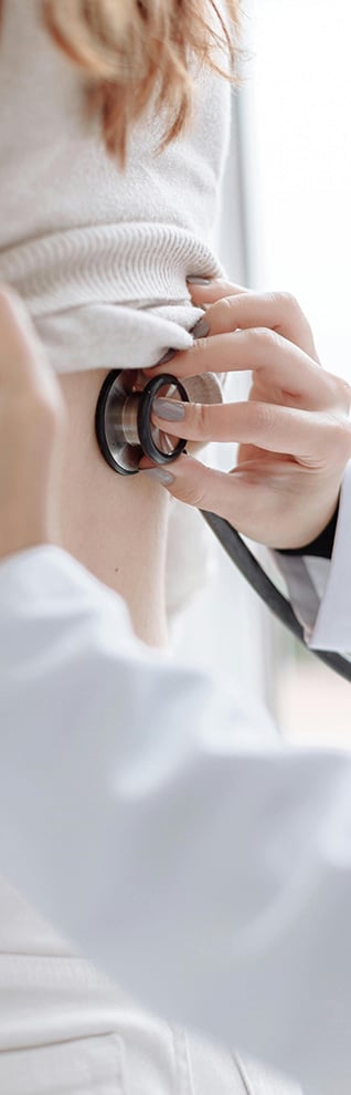 Doctor using stethoscope on patient